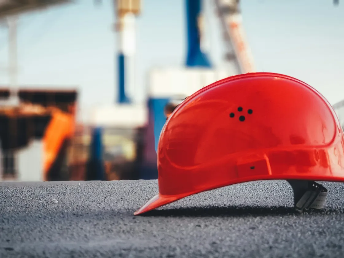Casque de chantier posé au sol sur un site industriel